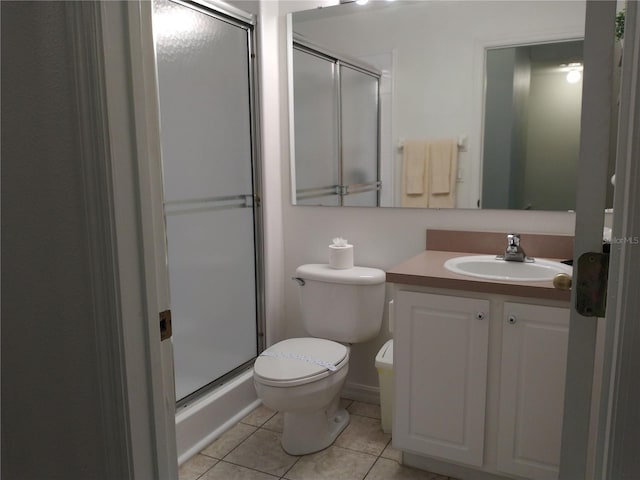 bathroom featuring tile patterned flooring, vanity, toilet, and a shower with door