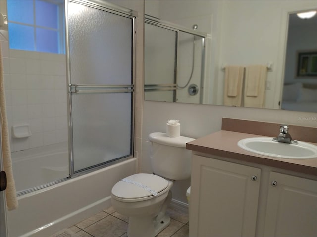 full bathroom with tile patterned flooring, combined bath / shower with glass door, toilet, and vanity