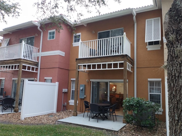 rear view of house featuring a balcony and a patio