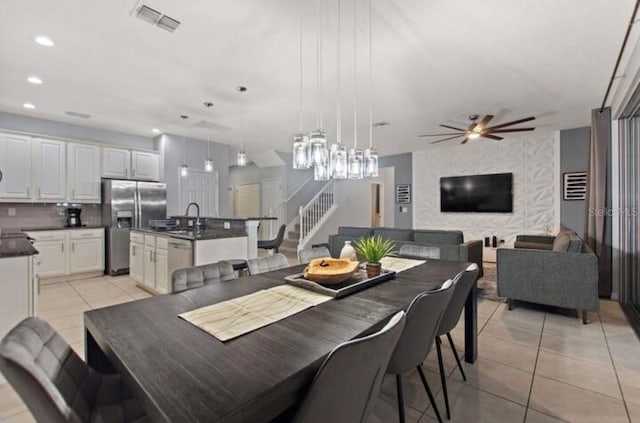 dining space featuring light tile patterned floors, ceiling fan, and sink