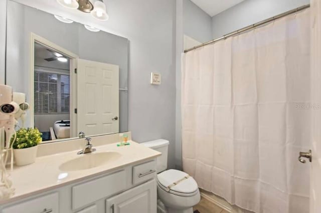 bathroom with a shower with curtain, vanity, and toilet