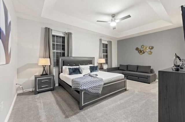 bedroom featuring a tray ceiling, ceiling fan, and light colored carpet