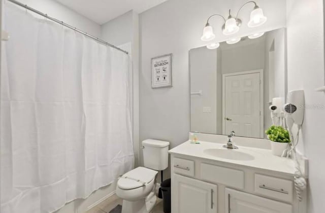 full bathroom featuring shower / bathtub combination with curtain, vanity, and toilet