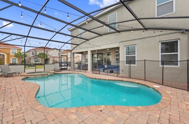 view of pool featuring a patio area, a lanai, and an in ground hot tub