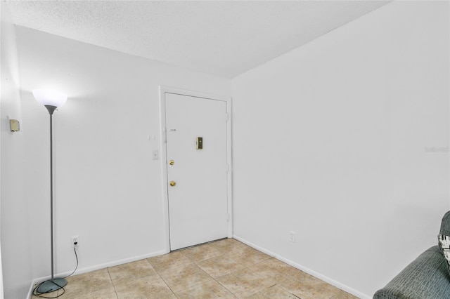 tiled spare room with a textured ceiling