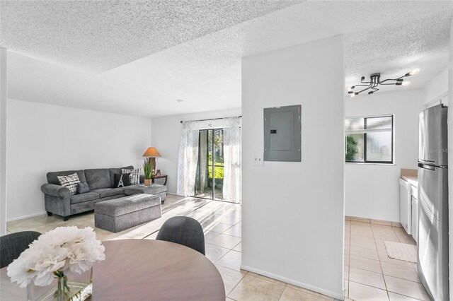 tiled living room featuring electric panel and a textured ceiling