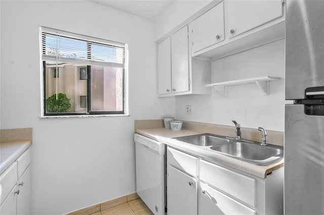 kitchen featuring stainless steel fridge, sink, dishwasher, white cabinetry, and light tile patterned flooring