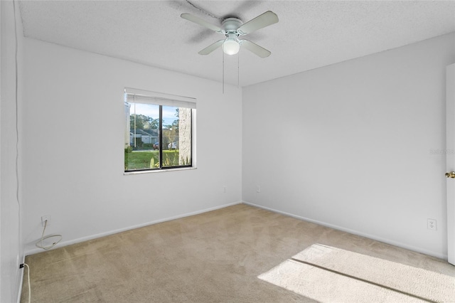 carpeted spare room featuring ceiling fan and a textured ceiling