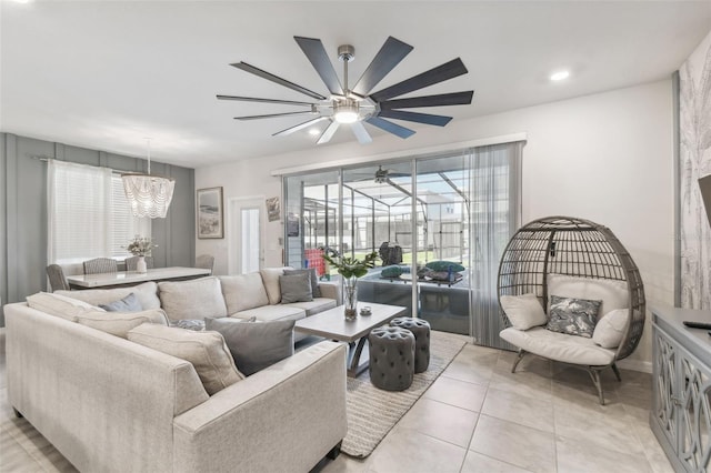 tiled living room featuring ceiling fan with notable chandelier