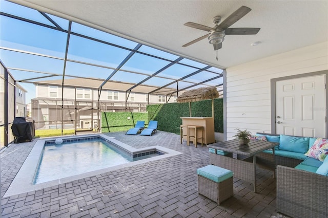 view of swimming pool featuring outdoor lounge area, grilling area, exterior bar, ceiling fan, and a patio area