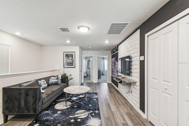 living room featuring wood-type flooring and a textured ceiling