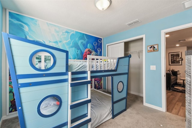 bedroom with hardwood / wood-style floors, a textured ceiling, and a closet