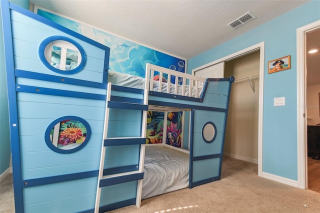 carpeted bedroom with a closet and a textured ceiling