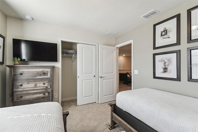 carpeted bedroom with a textured ceiling and a closet