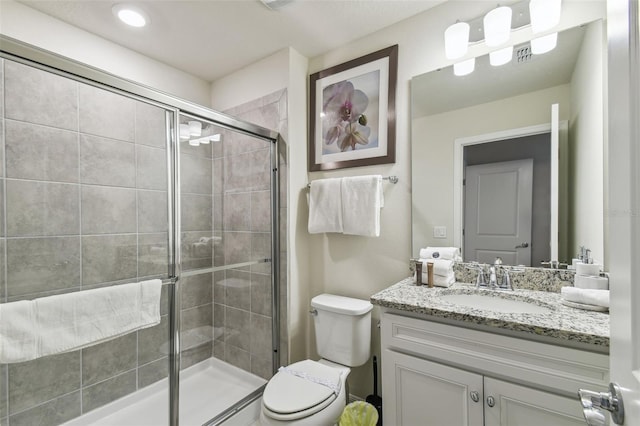 bathroom with toilet, vanity, and walk in shower