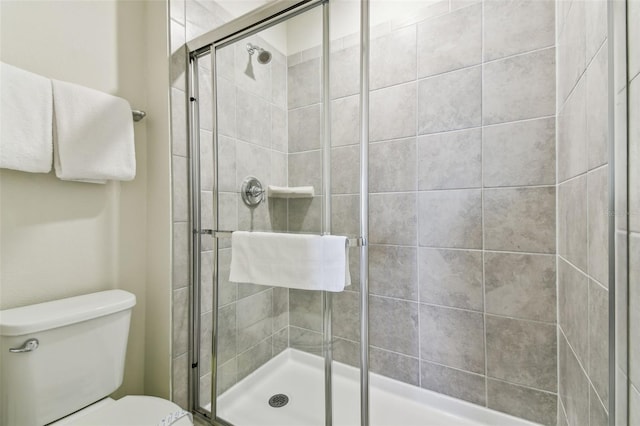 bathroom featuring toilet and an enclosed shower