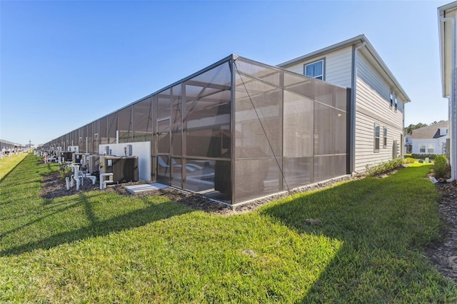 rear view of house with a lanai and a yard