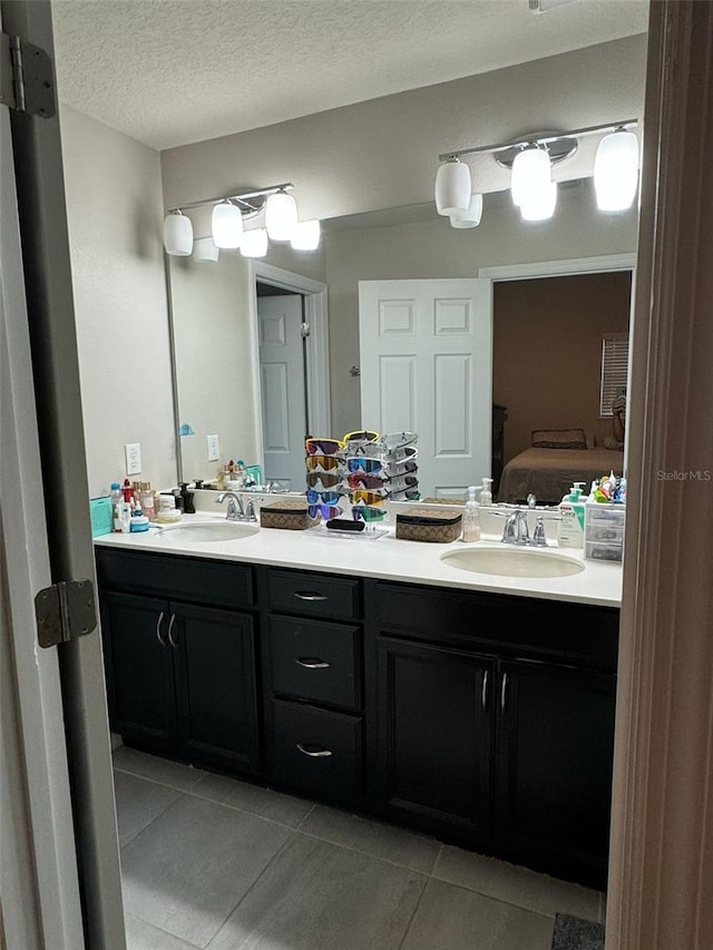 bathroom with tile patterned floors, vanity, and a textured ceiling