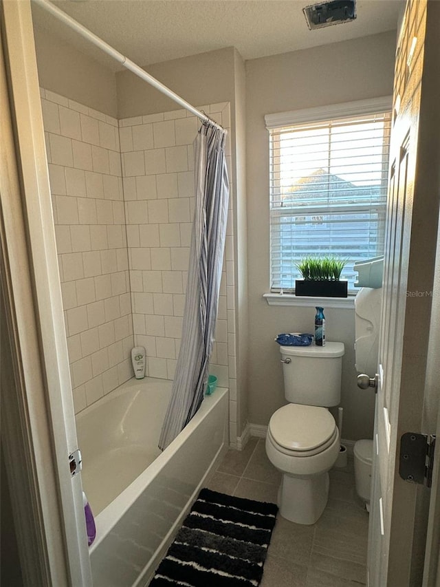 bathroom with toilet, a textured ceiling, tile patterned floors, and shower / tub combo with curtain