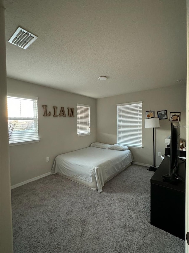 carpeted bedroom with a textured ceiling