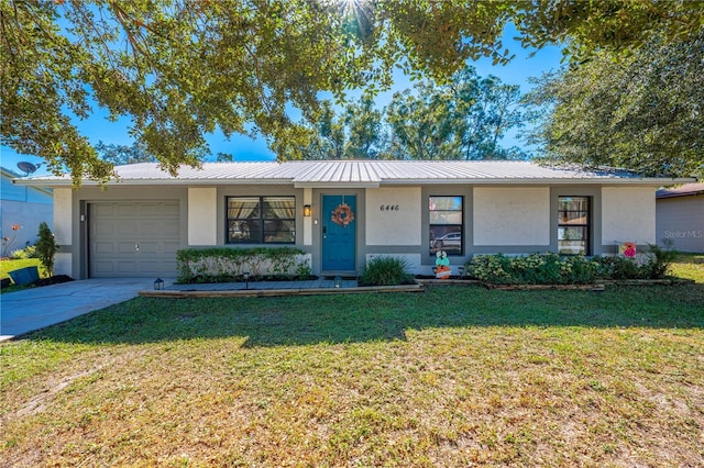 single story home with a garage and a front lawn