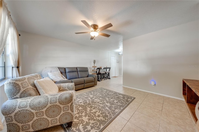 living room with ceiling fan, light tile patterned floors, and a textured ceiling