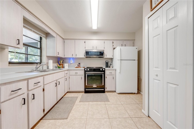 kitchen with black / electric stove, white cabinets, white fridge, and light tile patterned floors