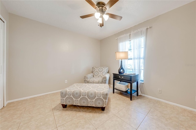 living area with light tile patterned floors and ceiling fan