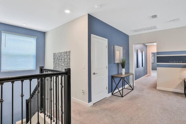 hallway with light colored carpet