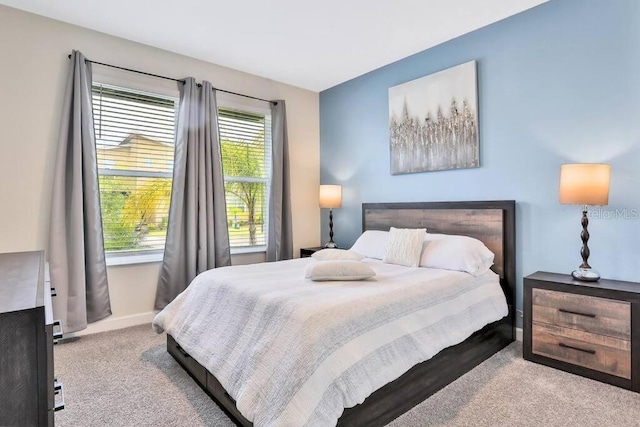 bedroom featuring light colored carpet and multiple windows