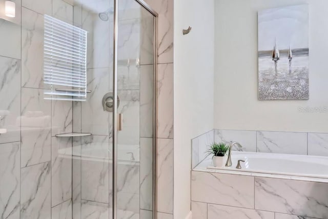 bathroom featuring shower with separate bathtub