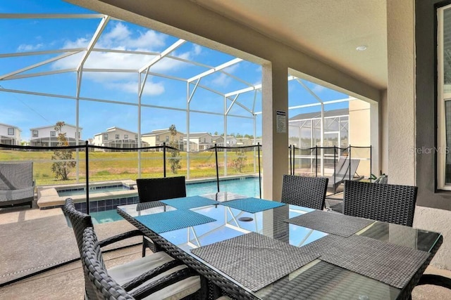 view of patio / terrace featuring a pool with hot tub and glass enclosure