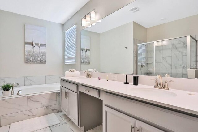 8932 Cabot Cliffs Dr, Davenport, FL 33896 - bathroom featuring double vanity, a garden tub, a shower stall, and marble finish flooring