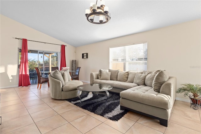 tiled living room featuring plenty of natural light, lofted ceiling, and an inviting chandelier