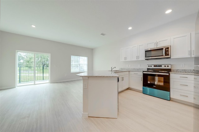 kitchen featuring sink, light stone countertops, light wood-type flooring, white cabinetry, and stainless steel appliances