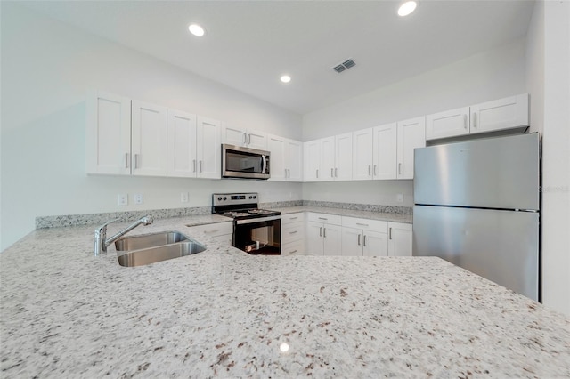 kitchen featuring white cabinets, stainless steel appliances, light stone countertops, and sink