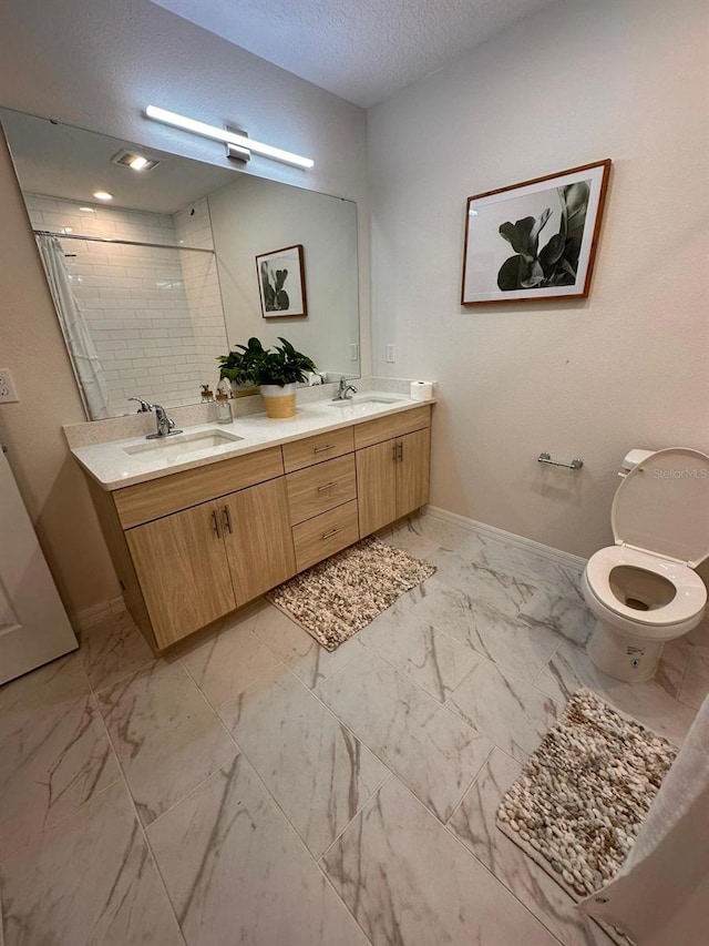 bathroom with toilet, vanity, a textured ceiling, and walk in shower