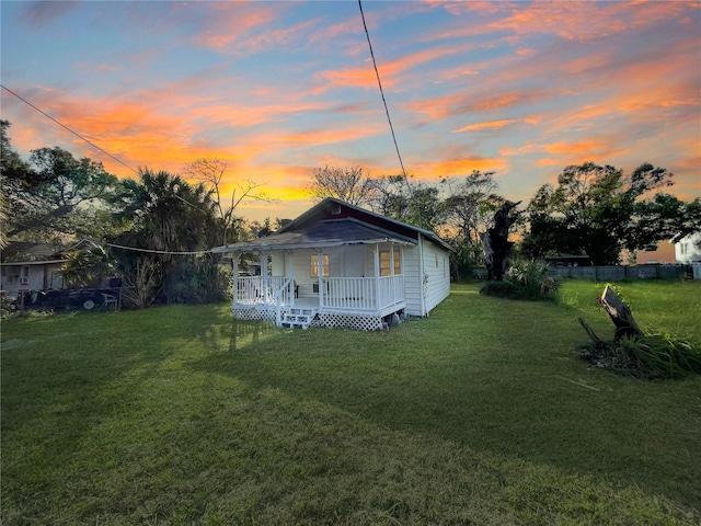 exterior space featuring covered porch and a yard