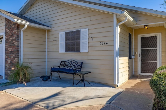 view of exterior entry with a patio