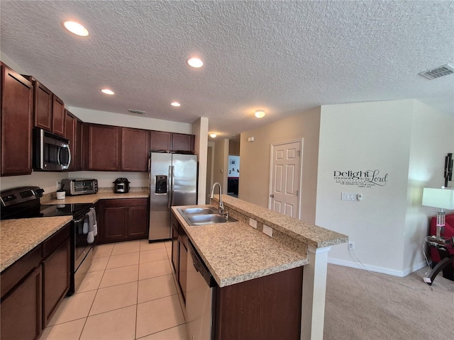 kitchen featuring a textured ceiling, stainless steel appliances, a kitchen island with sink, sink, and light tile patterned floors