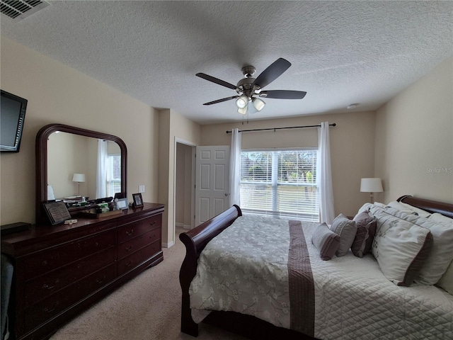 carpeted bedroom with a textured ceiling and ceiling fan