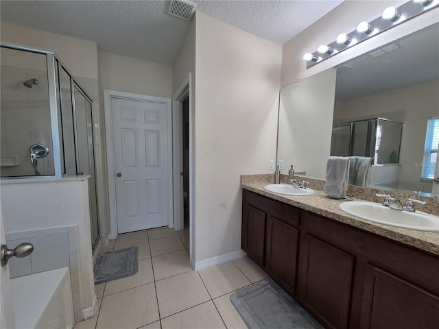 bathroom with tile patterned flooring, vanity, a textured ceiling, and independent shower and bath