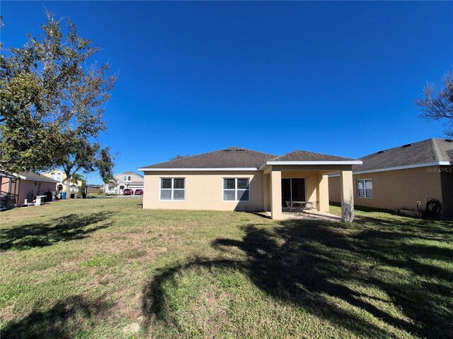 rear view of property with a yard and a patio