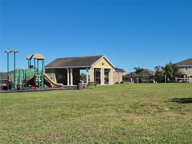 back of house featuring a yard and a playground