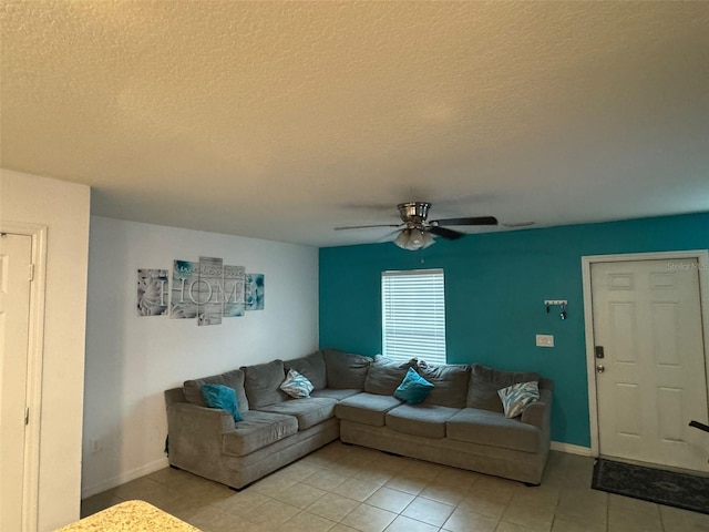 tiled living room featuring ceiling fan and a textured ceiling