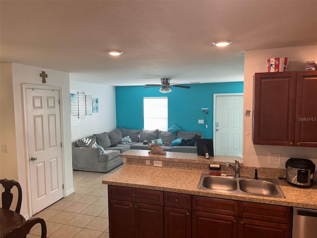 kitchen with sink, stainless steel dishwasher, ceiling fan, light tile patterned floors, and a textured ceiling