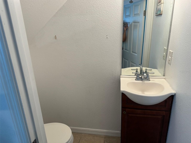 bathroom with tile patterned flooring, vanity, and toilet