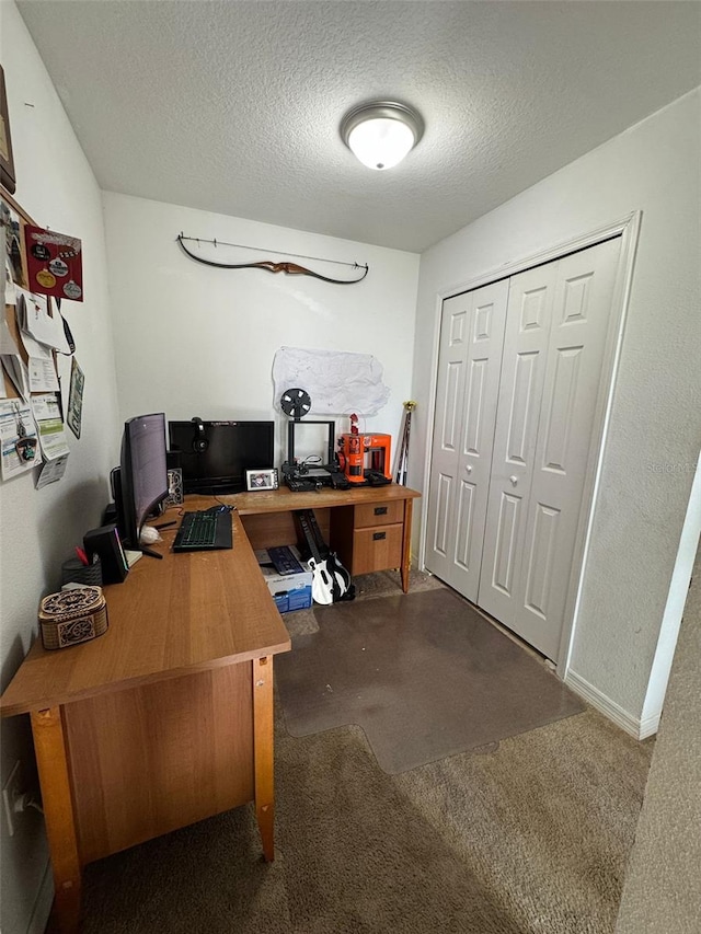 carpeted office featuring a textured ceiling