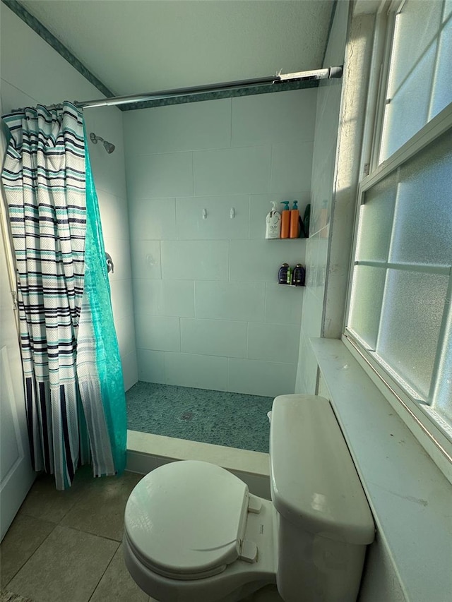 bathroom with tile patterned floors, curtained shower, and toilet