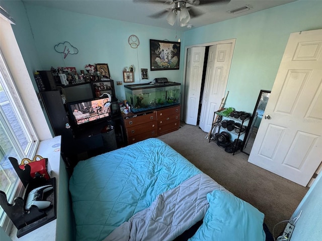 carpeted bedroom with ceiling fan and a closet